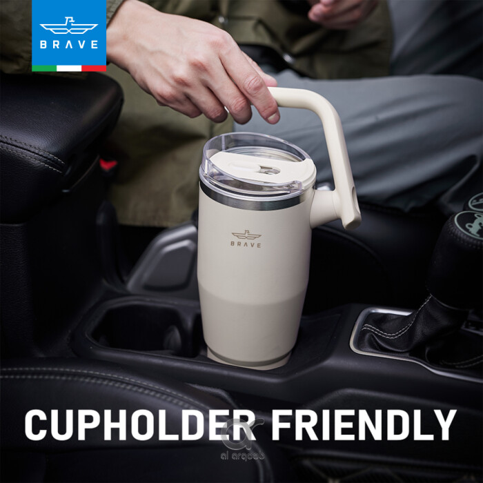 A neutral-toned Brave Tumbler Mug with a 180° rotating handle is shown fitting neatly into a car’s cup holder.