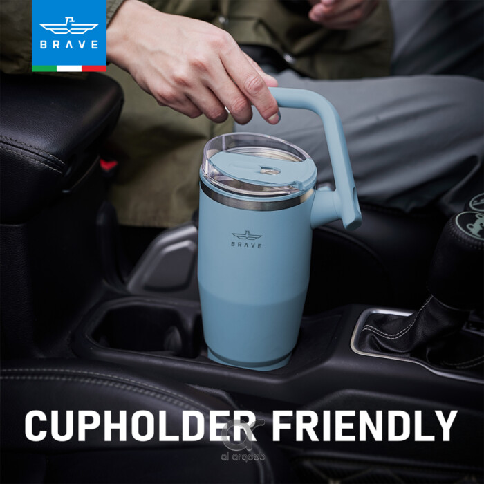 A blue-toned Brave Tumbler Mug with a 180° rotating handle is shown fitting neatly into a car’s cup holder. 