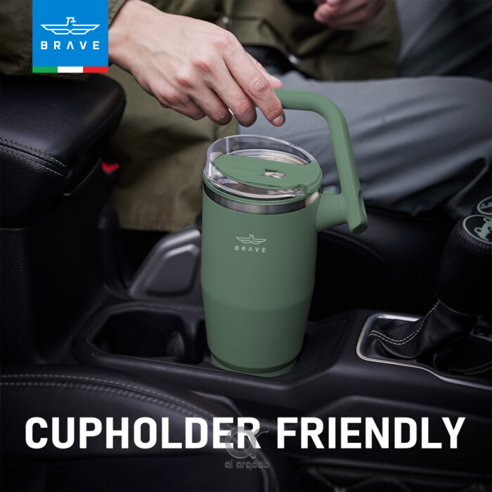 A green Brave Tumbler Mug with a 180° rotating handle is shown fitting neatly into a car’s cup holder.