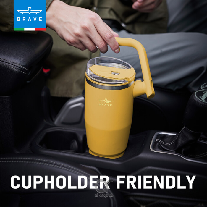 A pink Brave Tumbler Mug with a 180° rotating handle is shown fitting neatly into a car’s cup holder.