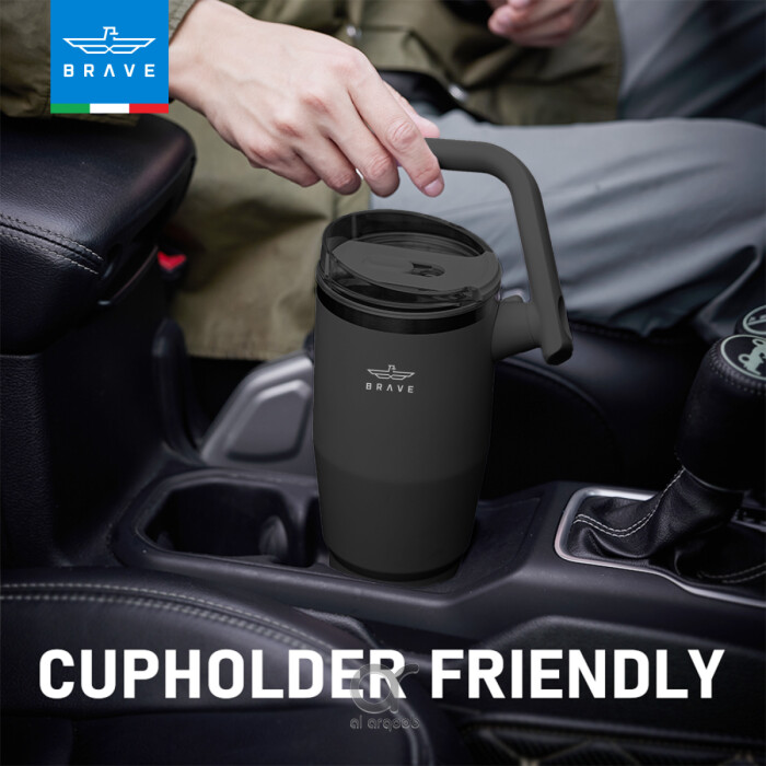 A black Brave Tumbler Mug with a 180° rotating handle is shown fitting neatly into a car’s cup holder. 